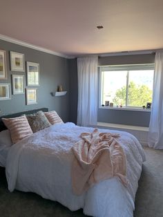 a bedroom with a large bed and pictures on the wall