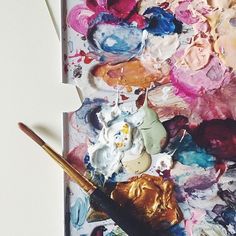 an artist's palette with paint and brushes