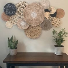 a table with some potted plants on it next to a wall mounted wicker basket