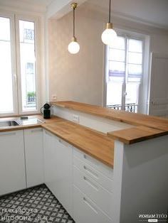 an empty kitchen with white cabinets and wood counter tops