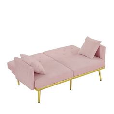 a pink couch with gold legs and pillows