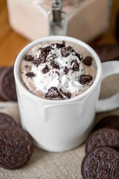 a cup of hot chocolate with whipped cream and oreo cookies