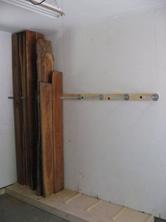 an unfinished room with some wooden pieces on the floor and a door in the wall