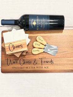 a wine bottle and corkscrews on a cutting board with the words cheers, wine cheese & friends only get better with age