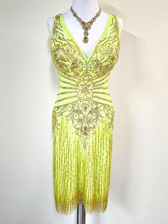 a yellow flap dress on a mannequin with beading and fringed details