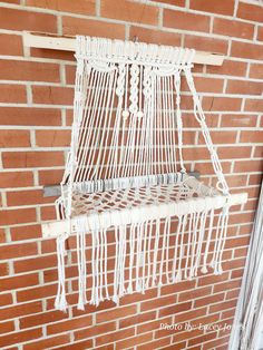 a white hammock hanging on a brick wall