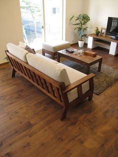 a living room filled with furniture and a flat screen tv on top of a wooden table