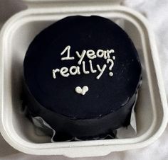 a black cake with the words 1 year really written on it in a foam container