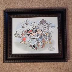 a framed mickey and minnie mouse poster hanging on the wall