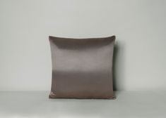 a gray pillow sitting on top of a white table