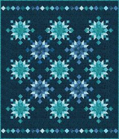 a blue and white quilt with snowflakes on the front, in shades of teal