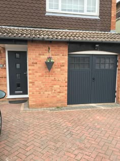 a bicycle parked in front of a brick building with two garage doors on each side