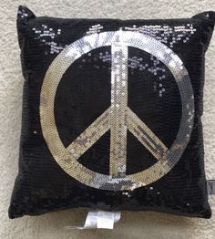 a peace sign sequin pillow is on display in a store's showroom