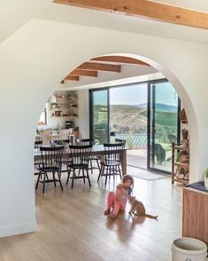 two children playing on the floor in front of an open living room with sliding glass doors