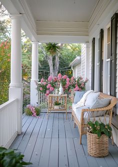 a porch with wicker furniture and pink flowers