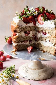 there is a cake with strawberries on the top and one slice cut from it