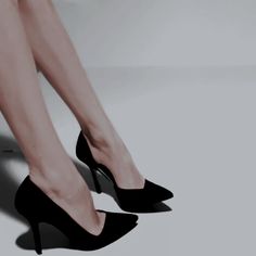 a woman's legs in high heels on a white surface with light reflecting off the floor