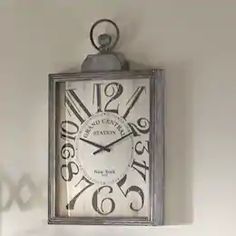 a clock hanging from the side of a wall