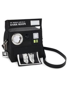 Look ghostly-good with this crossbody camera bag inspired by the one Lydia Deetz carries in Beetlejuice! This camera bag features the text, "My whole life is a dark room" along with ghost photo accents and a gleaming faux lens. A secure zipper closure and adjustable strap make this Beetlejuice bag picture perfect. Officially licensed Adjustable strap Zipper closure Material: Polyurethane, polyester Care: Spot clean Imported Accessory Wall, Ghost Photo, Bag Picture, Crossbody Camera Bag, Titanium Belly Ring, A Dark Room, Labret Jewelry, Lydia Deetz, Ghost Photos