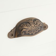 an ornate door handle on a white wall