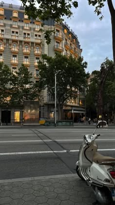 a scooter is parked on the side of the road in front of a hotel