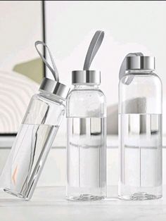 three glass bottles with silver lids and spoons