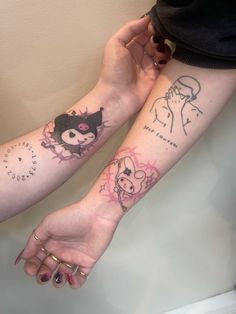 two people holding hands with tattoos on their arms and wrist, one has a cat and the other has a dog