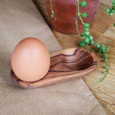 an egg in a wooden bowl on a table