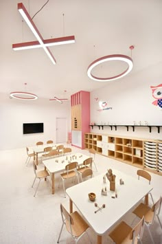 an empty classroom with wooden tables and chairs