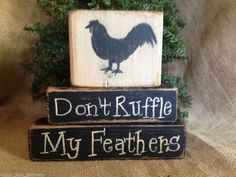 two wooden blocks with black and white painted roosters on them, one says don't ruffle my feathers