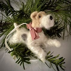 a stuffed dog laying on top of a tree branch with a ribbon around it's neck