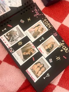 a black notebook with pictures on it sitting on a red and white checkered blanket