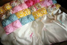 an unmade quilt is laying on top of a bed sheet with pink, yellow and blue flowers