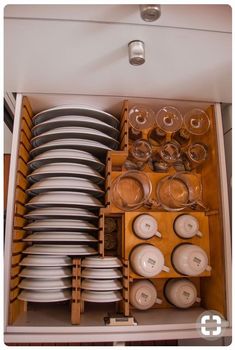 a cabinet filled with lots of dishes and plates in it's drawers, all stacked together