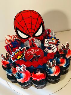 the cupcakes are decorated with spider - man images and other edible items on them