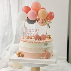 a three tiered cake with balloons on top