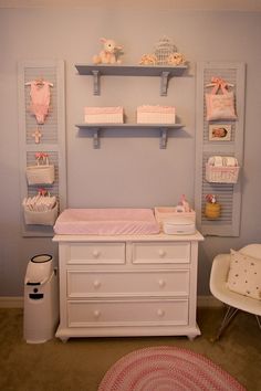 a baby's room with blue walls and white furniture