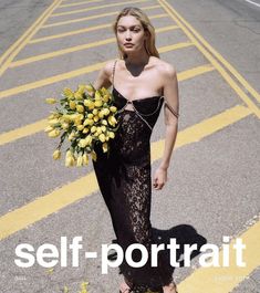 a woman is walking down the street with flowers in her hand and wearing a black dress