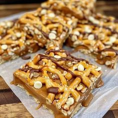 several pieces of chocolate covered pretzel bars on wax paper with nuts in the middle