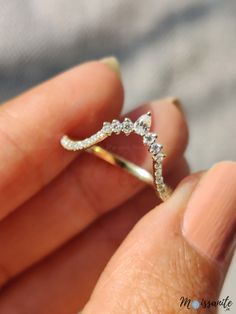 a person holding a diamond ring in their hand