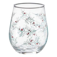 a glass with red berries and green leaves on it