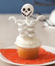 a cupcake with white frosting and a skeleton on top