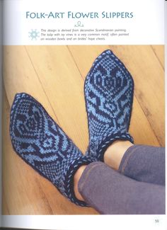 a woman's feet in blue knitted slippers on a wooden floor with her legs crossed