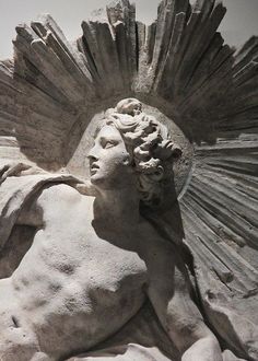 a statue is shown with an angel on it's head and wings in the background