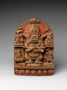 an ornately carved wooden sculpture with buddhas on it