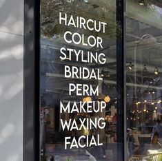 there are many signs in the window of this store that says, haircut color styling bridal perm makeup waxing facial