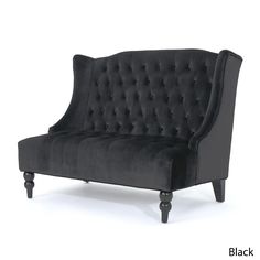 a black velvet couch with wooden legs and buttons on the back, in front of a white background