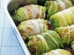 some food is in a white dish on a blue tablecloth and it looks like cabbage