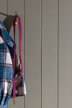 a blue and white plaid coat hanging from a hook