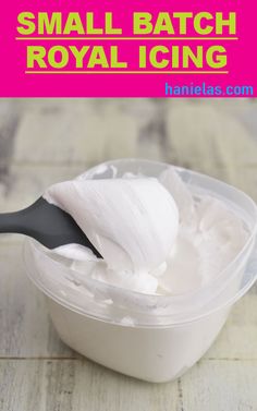 small batch royal icing in a plastic container with a black spoon on the side